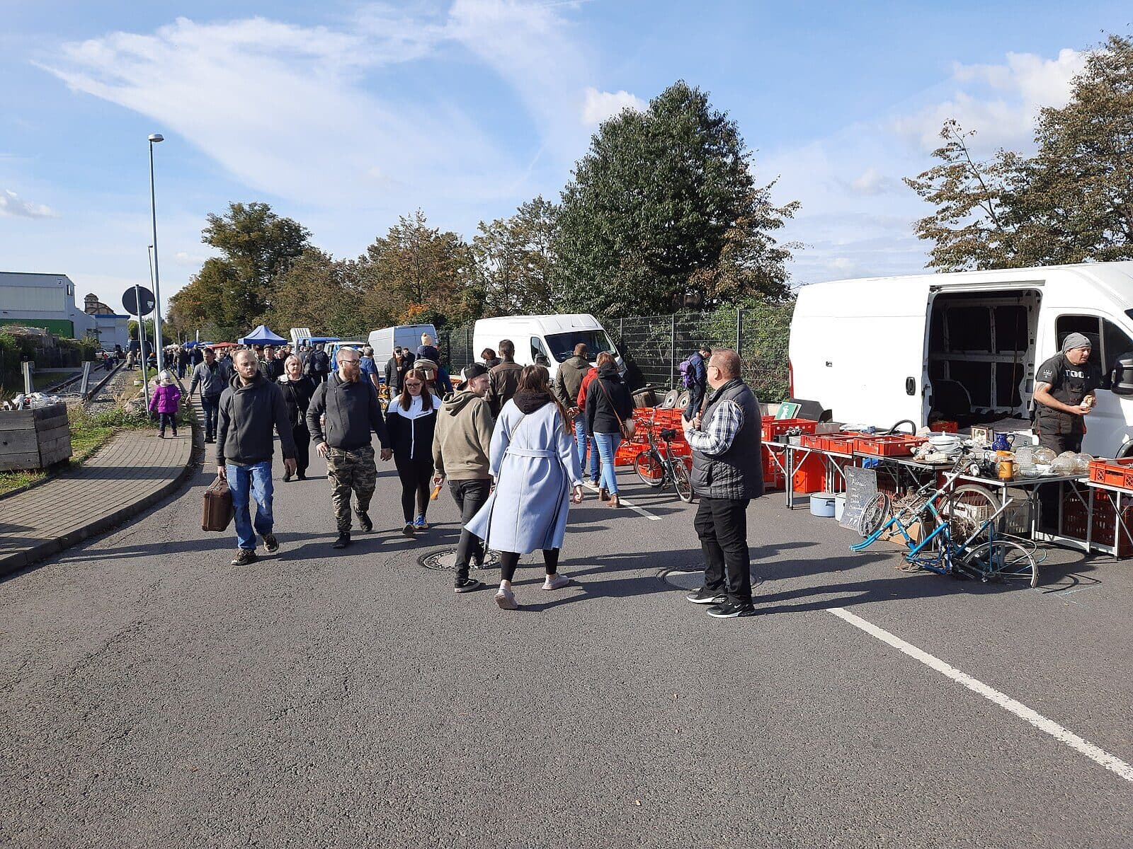 Besucher zwischen Verkaufsständen und Lieferwagen auf einem Oldtimer-Teilemarkt
