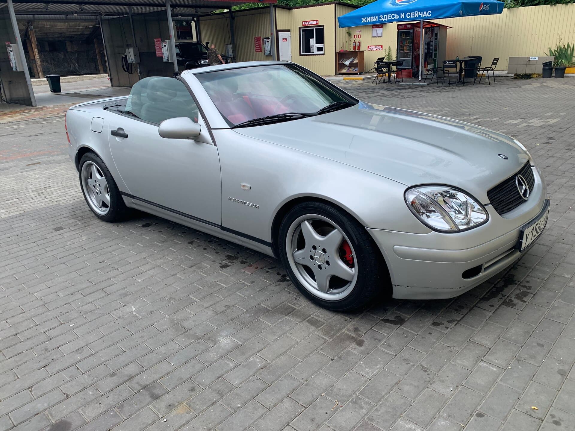 Ein silberner Mercedes SLK R170 von 1999 mit geschlossenem Variodach auf einem Parkplatz