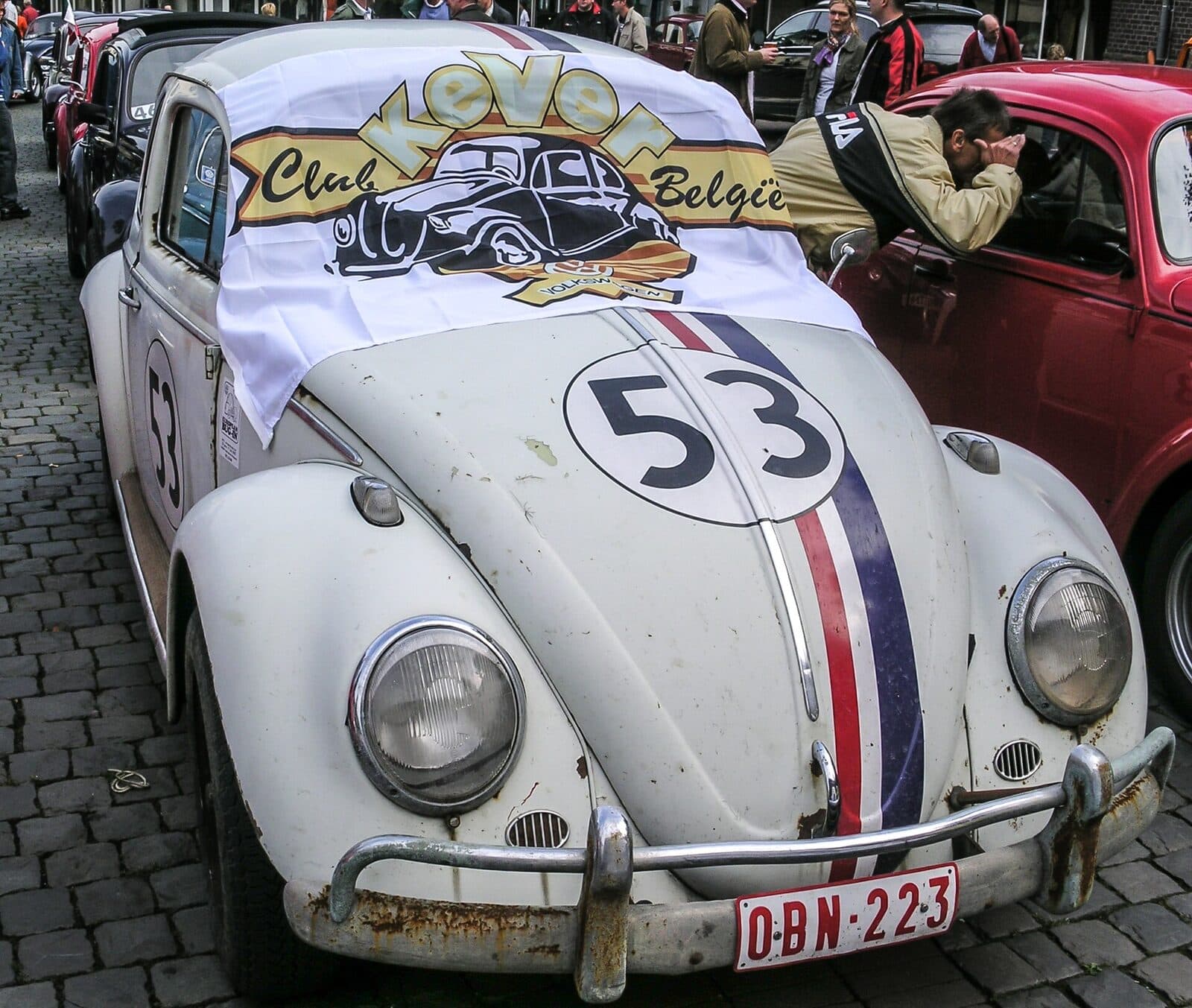 Internationaal steht im alten Namen, und es ist wörtlich gemeint: Clubs aus Belgien, Deutschland und Frankreich kommen seit Jahrzehnten. Auch dieses Bild entstand 2007 in Dülmen. Foto: Dietmar Rabich, Wikimedia Commons, CC BY-SA 4.0, skaliert. Ein weißer VW Käfer mit der Startnummer 53 und einem Banner eines belgischen Clubs, dahinter weitere Käfer