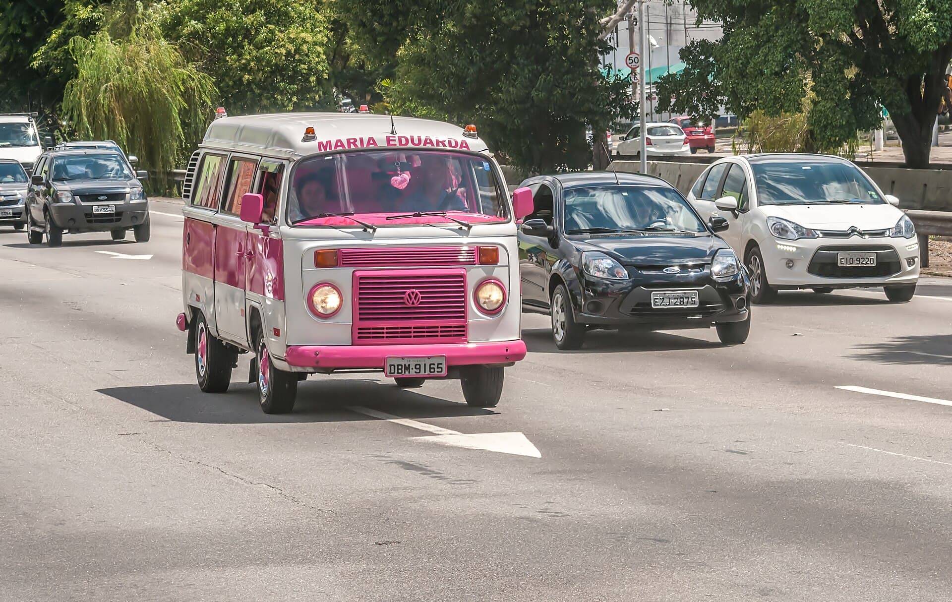 Ein Kombi im Verkehr von São Paulo. Gebaut wurde er gleich nebenan in São Bernardo do Campo. Foto: Wilfredor, Wikimedia Commons, CC BY-SA 4.0, skaliert. Ein rosa-weißer VW Kombi T2 im Straßenverkehr von São Paulo
