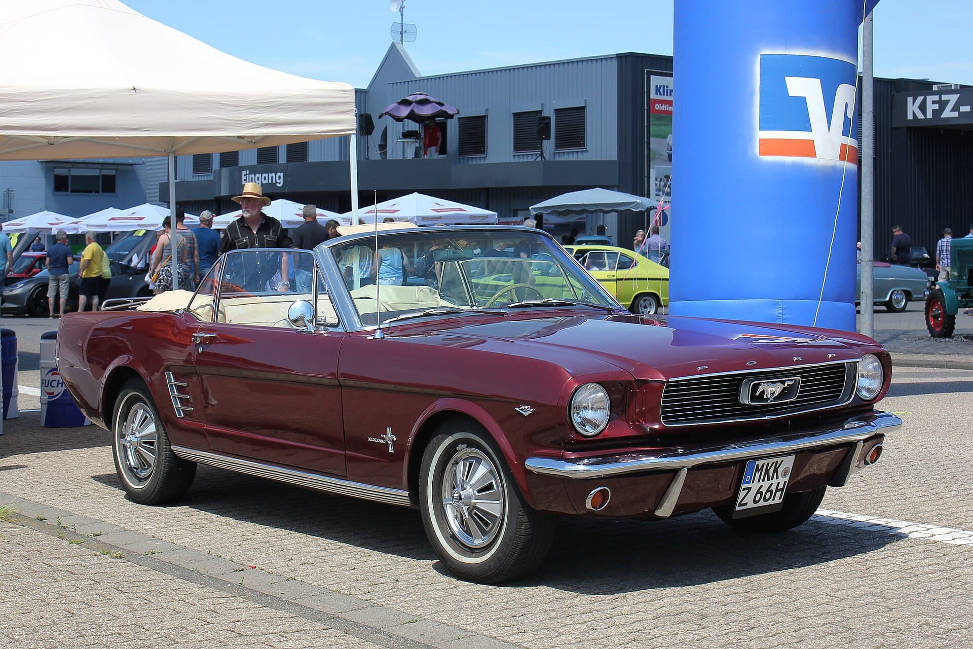 Ein Mustang Cabriolet von 1966 mit deutschem Kennzeichen. In den ersten 15 Jahren hieß so ein Wagen hierzulande T5. Foto: Lothar Spurzem, Wikimedia Commons, CC BY-SA 2.0 de, skaliert. Ein weinrotes Ford Mustang Cabriolet von 1966 mit deutschem Kennzeichen auf einem Oldtimertreffen