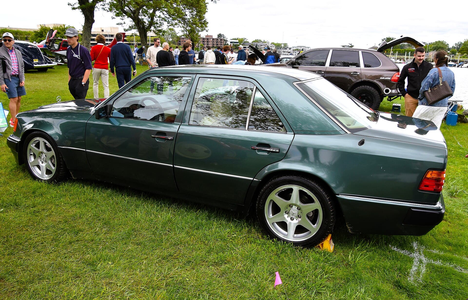 Von der Seite zeigt sich, was Porsche gebaut hat: die 56 mm breitere Karosserie mit den ausgestellten Radläufen und den 8 x 16 Zoll großen Achtloch-Rädern. Foto: Charles (Port Chester, New York), Wikimedia Commons, CC BY 2.0, skaliert. Ein dunkelgrüner Mercedes 500 E von 1992 von der Seite, mit den breiten Radläufen und Achtloch-Rädern