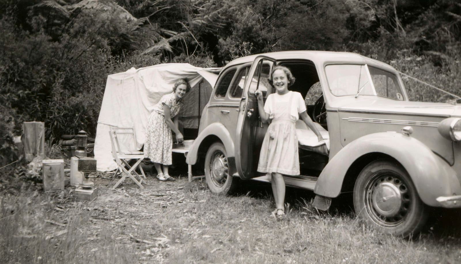 Familienfotos sind oft die einzigen Bilder aus dem frühen Leben eines Wagens. Sie zeigen Farbe, Felgen und Zubehör von damals. Aufnahme: Leslie E. Chambers, 1951, Museums Victoria. Ein Mädchen neben einem Auto auf einem alten Schwarzweißfoto