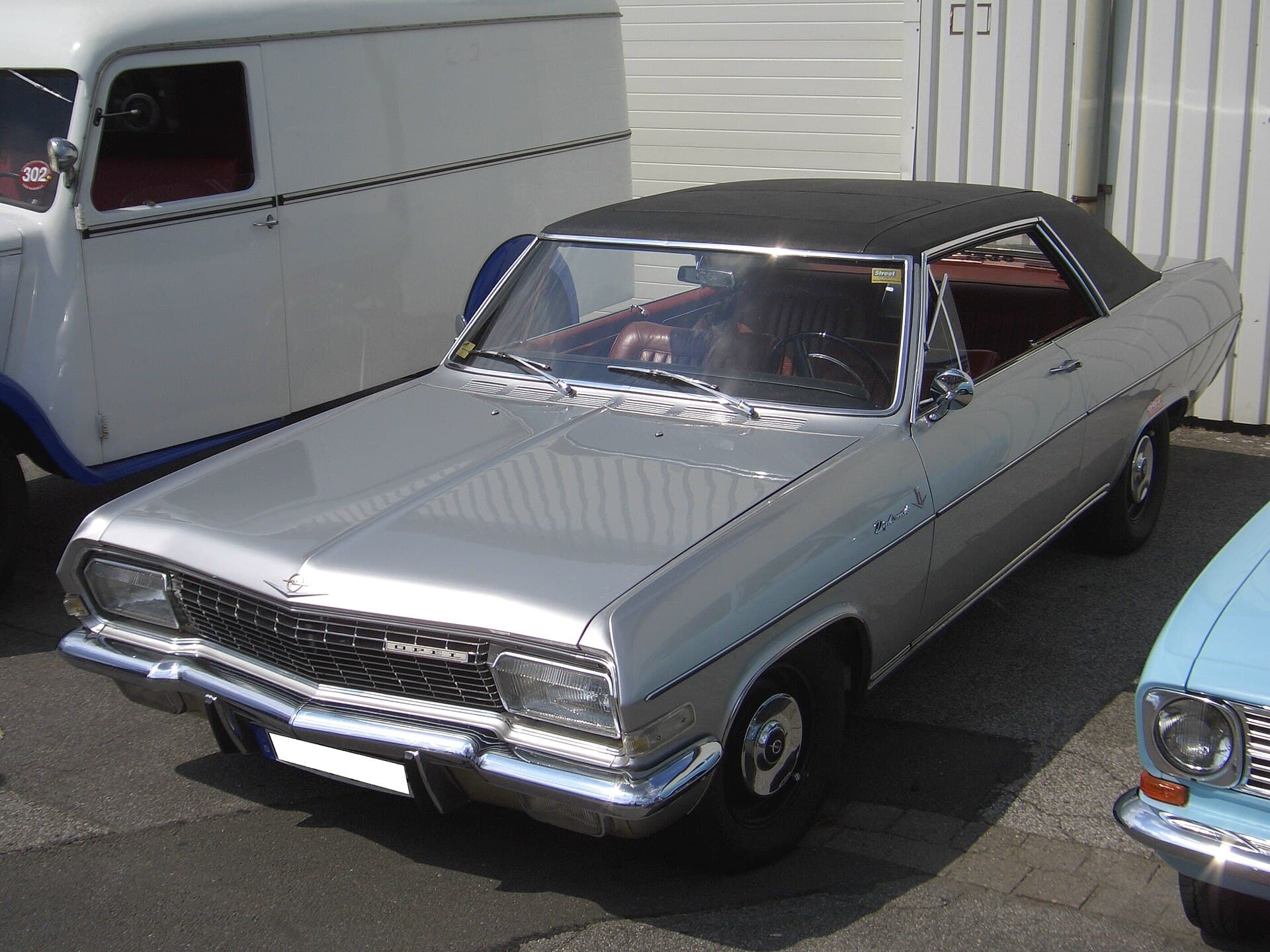 Ein Diplomat V8 Coupé von Karmann, gebaut zwischen 1965 und 1967, bei einem Treffen in Leverkusen. Foto: Detectandpreserve, Wikimedia Commons, CC BY-SA 3.0, skaliert. Ein silbernes Opel Diplomat A V8 Coupé mit schwarzem Vinyldach