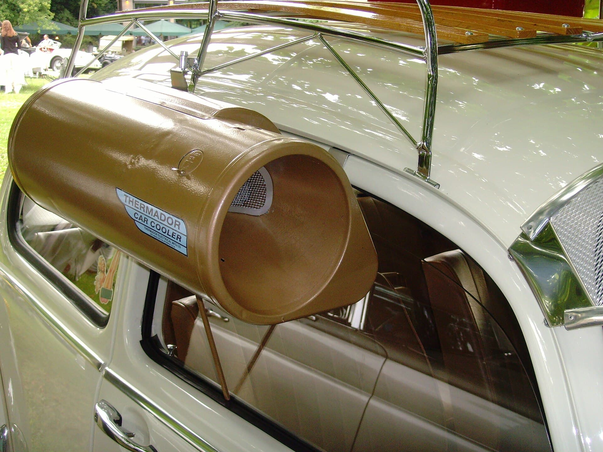 So hängt er richtig: Öffnung nach vorn in den Fahrtwind, der Auslass durch den Spalt der fast geschlossenen Scheibe. Foto: Klaus Nahr, Wikimedia Commons, CC BY-SA 2.0, skaliert. Ein Thermador Car Cooler am Beifahrerfenster eines hellen Oldtimers, die Öffnung nach vorn, der Auslass im Fenster