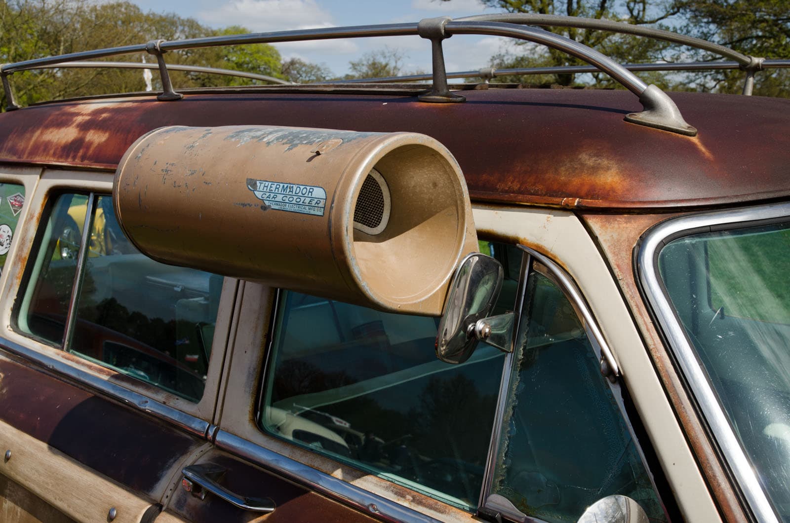 Ein Original mit Patina an einem Ford Kombi von 1954. In diesem Zustand wechseln Thermador-Geräte heute für 400 bis 600 Dollar den Besitzer. Foto: SG2012, Wikimedia Commons, CC BY 2.0, skaliert. Ein verwitterter Thermador Car Cooler am Fenster eines Ford Country Squire von 1954 mit Dachgepäckträger