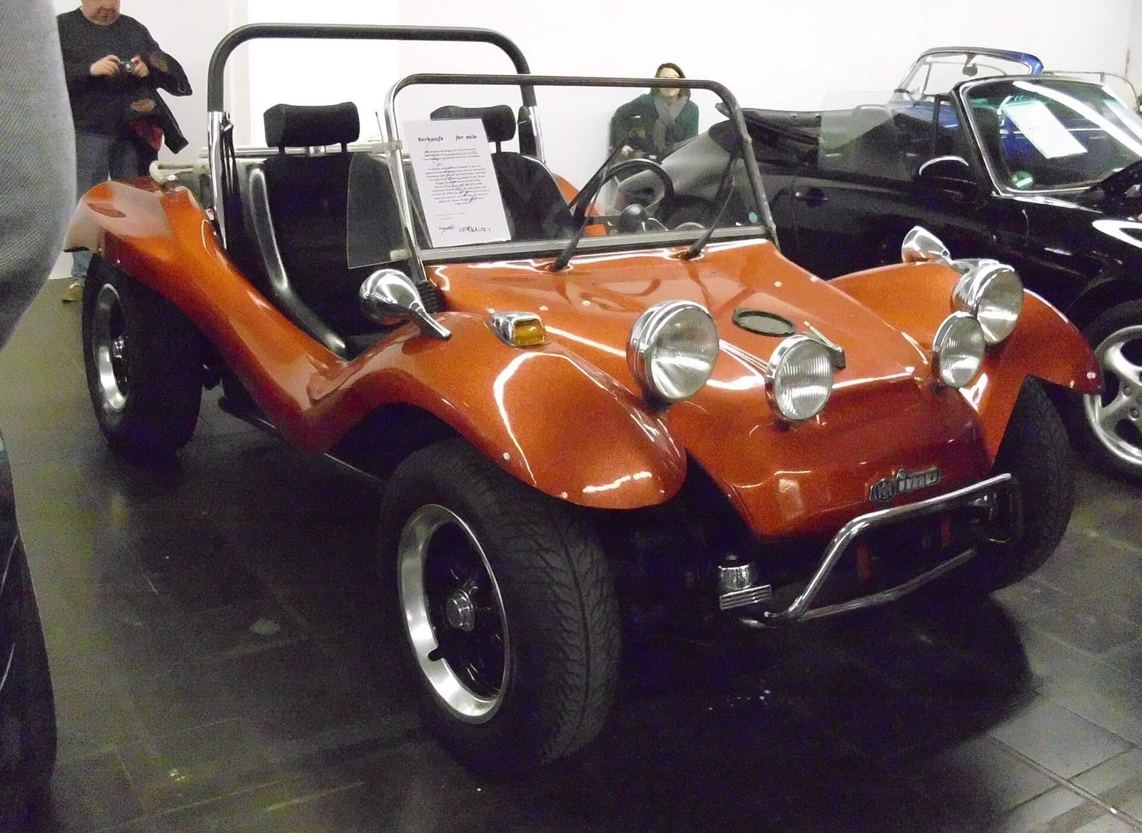 Ein AHS Imp von 1970 aus Göttingen. Foto: Buch-t, Wikimedia Commons, CC BY-SA 3.0 de, skaliert. Ein orangefarbener AHS Imp Buggy von 1970 mit Zusatzscheinwerfern in einer Halle