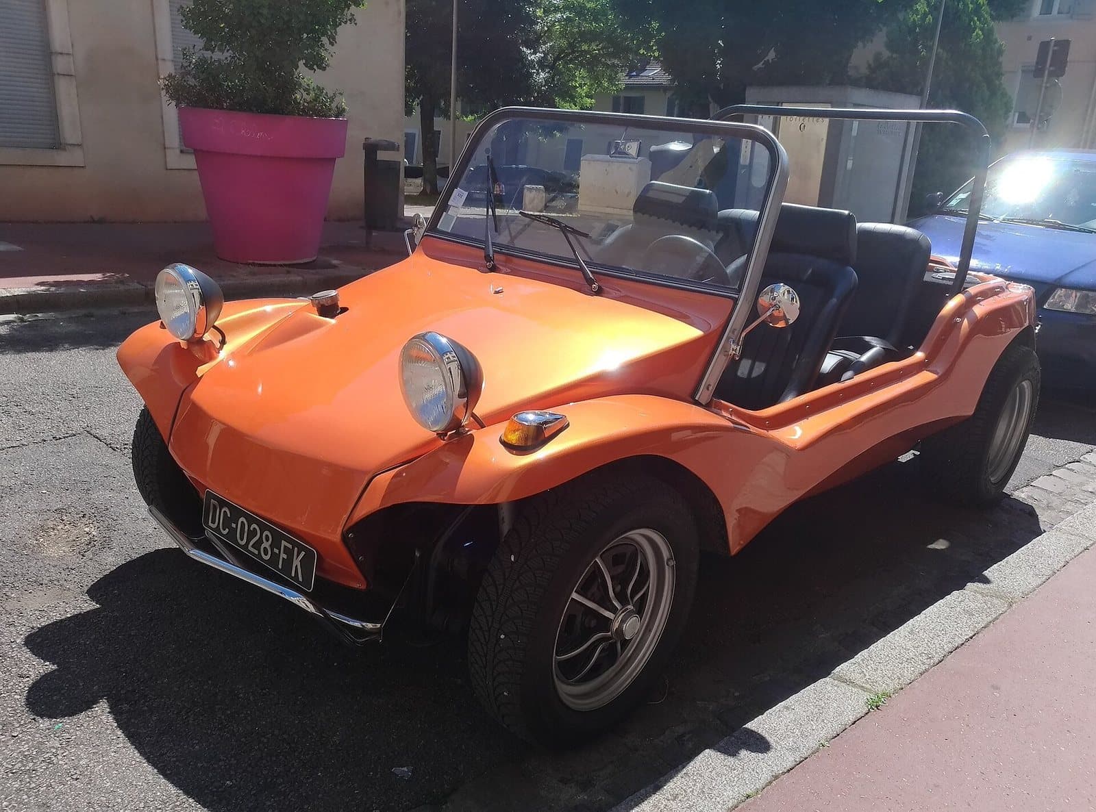 Ein Apal Buggy in Chalon-sur-Saône, 2018. Foto: Guillaume Vachey, Wikimedia Commons, CC0, skaliert. Ein orangefarbener Apal Buggy mit Chromscheinwerfern an einer Straße in Frankreich