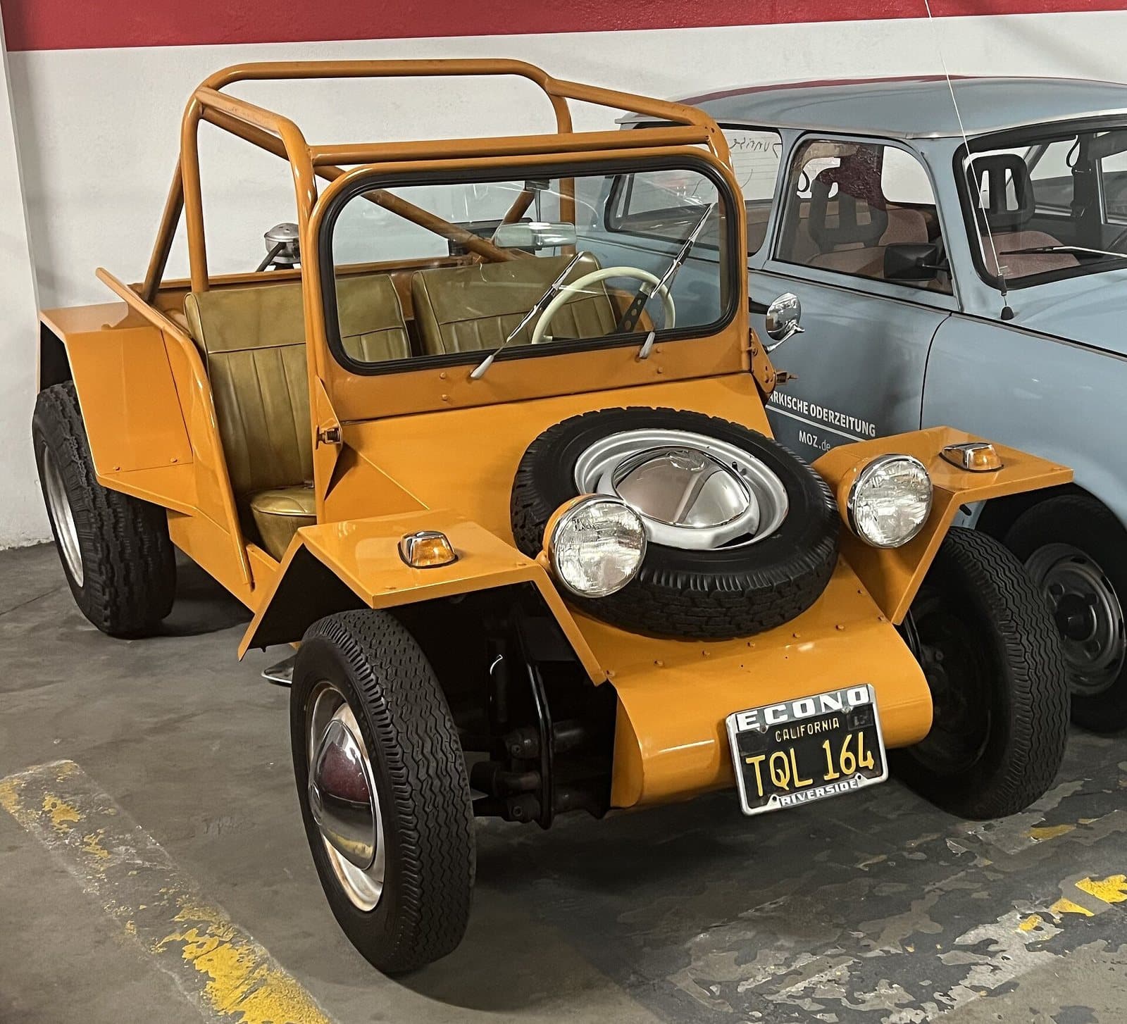 Ein EMPI Sportster mit Karosserie aus Stahlblech im Petersen Automotive Museum. Foto: TaurusEmerald, Wikimedia Commons, CC BY-SA 4.0, skaliert. Ein ockerfarbener EMPI Sportster mit kantiger Blechkarosserie und Überrollkäfig