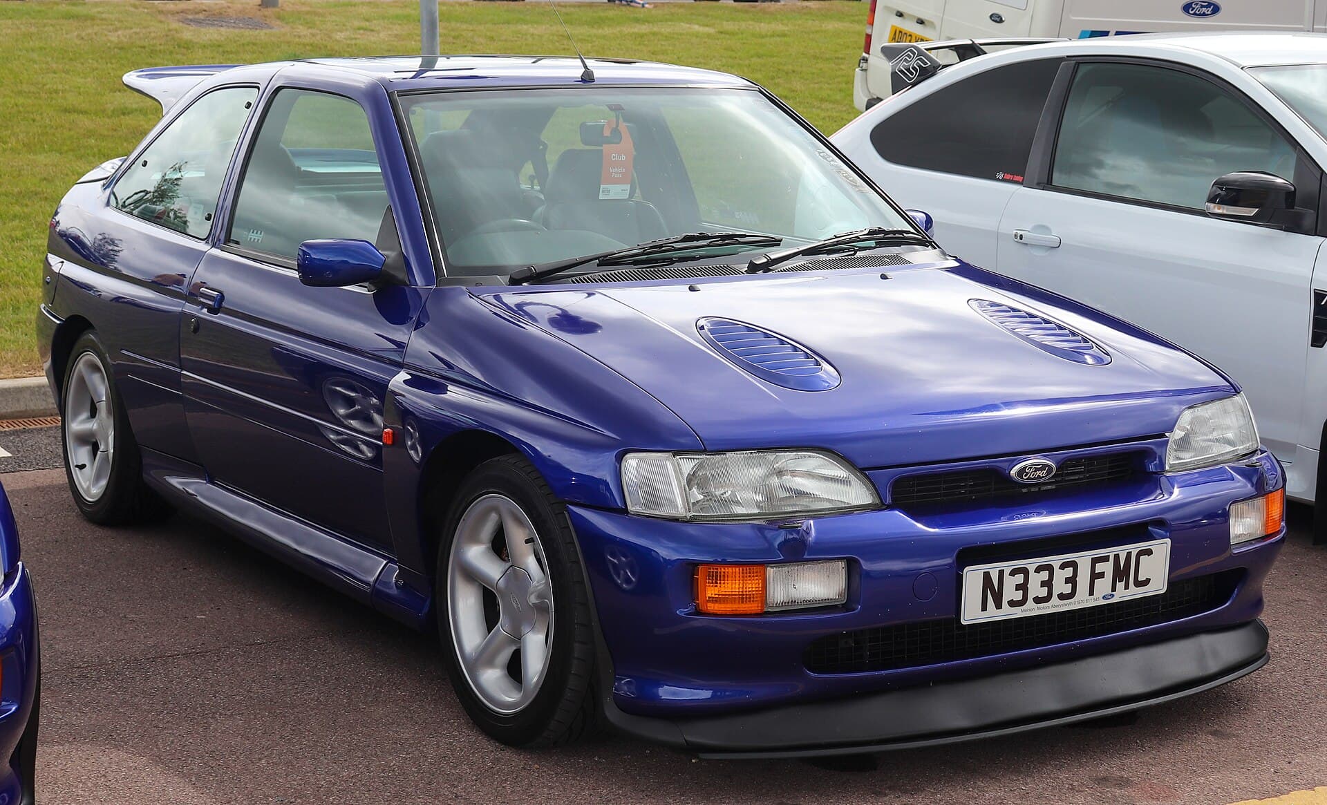 Ein Escort RS Cosworth mit britischer Zulassung von 1996: der Flügel, die Lufthutzen auf der Haube und die 8 mal 16 Zoll großen Räder von Ford RS. Ein Ford Escort RS Cosworth in Blau von vorn, mit Heckflügel und den Rädern von Ford RS