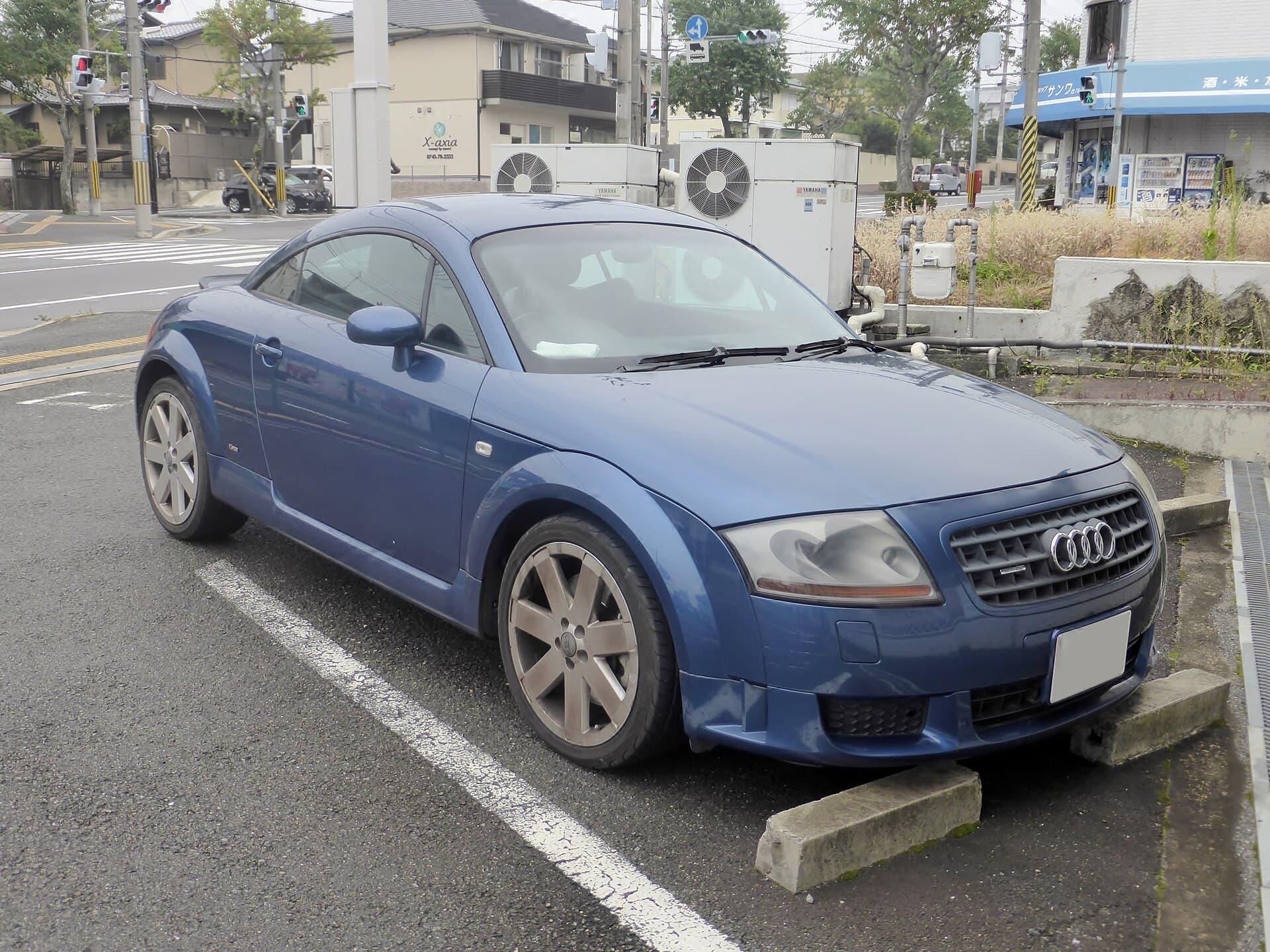 Ein TT Coupé 8N in Blau: der Bogen des Dachs, die runden Radhäuser und die Abrisskante am Heck, die seit 2000 dazugehört. Ein blauer Audi TT Coupé der ersten Generation von schräg vorn